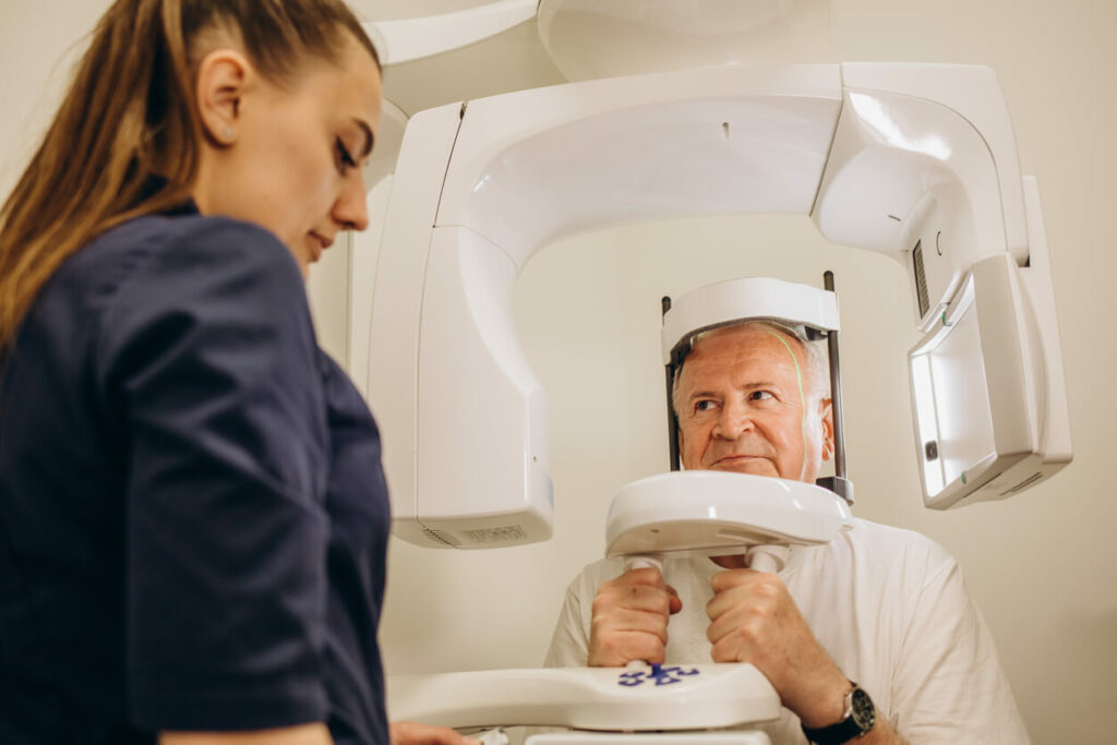 A male adult is undergoing a medical screening conducted by a female doctor.