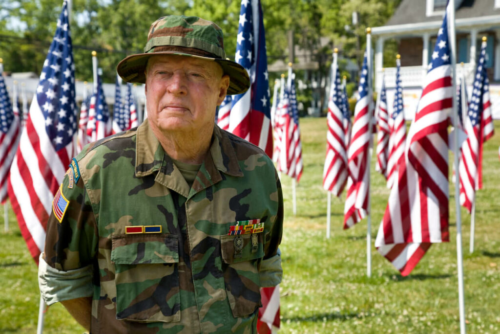 Veteran among American Flags looking away