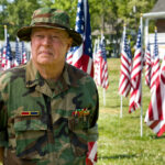 Veteran among American Flags looking away