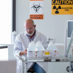 A male scientist is working with hazardous materials in an environment exposed to radiation.