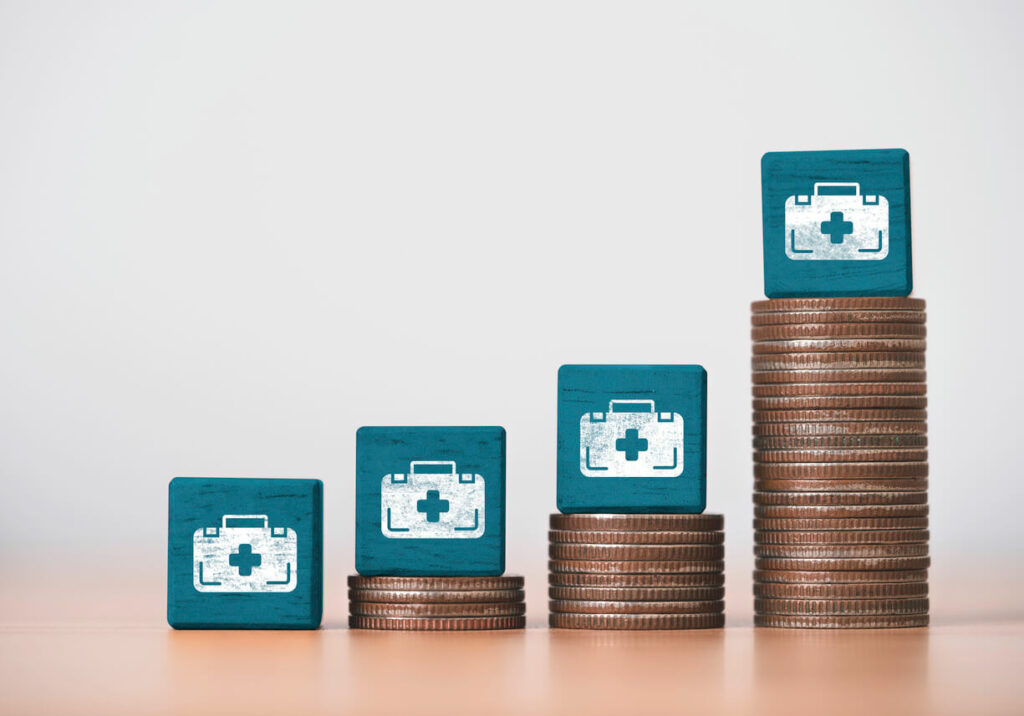 Image of increasing stacks of coins beside a medical bag to illustrate funding for cancer medical expenses and treatment.