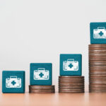Image of increasing stacks of coins beside a medical bag to illustrate funding for cancer medical expenses and treatment.