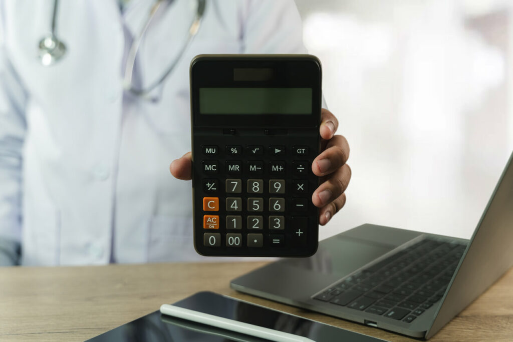 A medical practitioner holding a calculator to illustrate medical expenses and the concept of cancer funds.