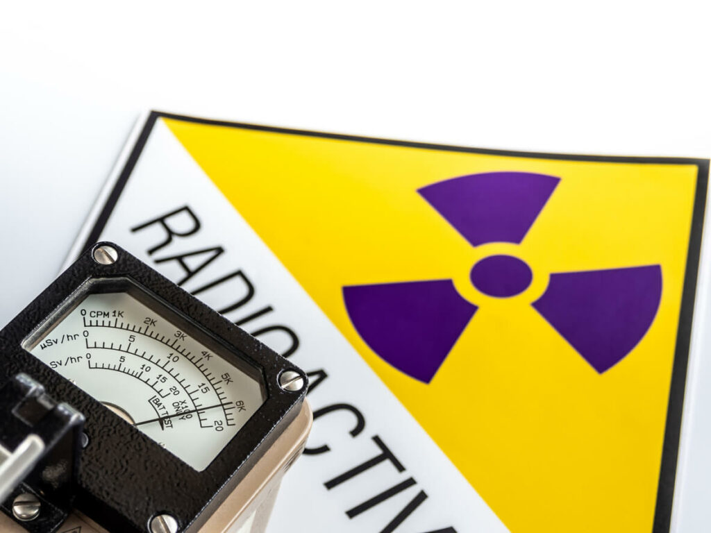 An image of a hand-held radiation survey meter detecting radiation exposure linked to cancer.