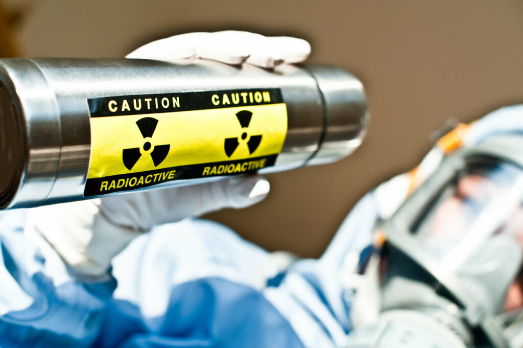 Radiation R&D Scientist Examines Blue Radioactive Liquid Substance in Beaker.