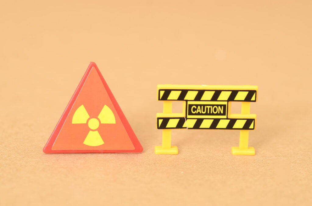 The caution sign and barricade clearly indicate a hazardous area due to the presence of radiation.