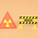 The caution sign and barricade clearly indicate a hazardous area due to the presence of radiation.